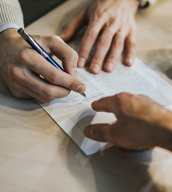 lawyer points to where to sign on legal document